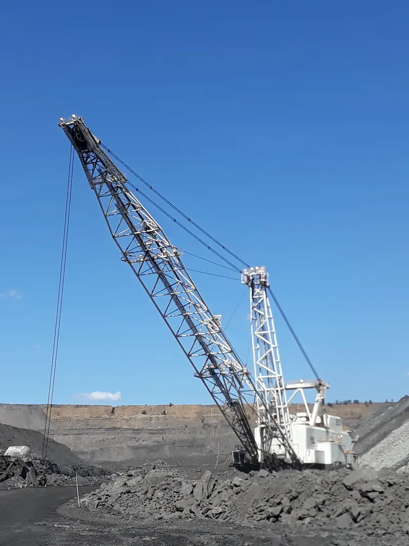 Dragline working in the pit under a clear blue sky